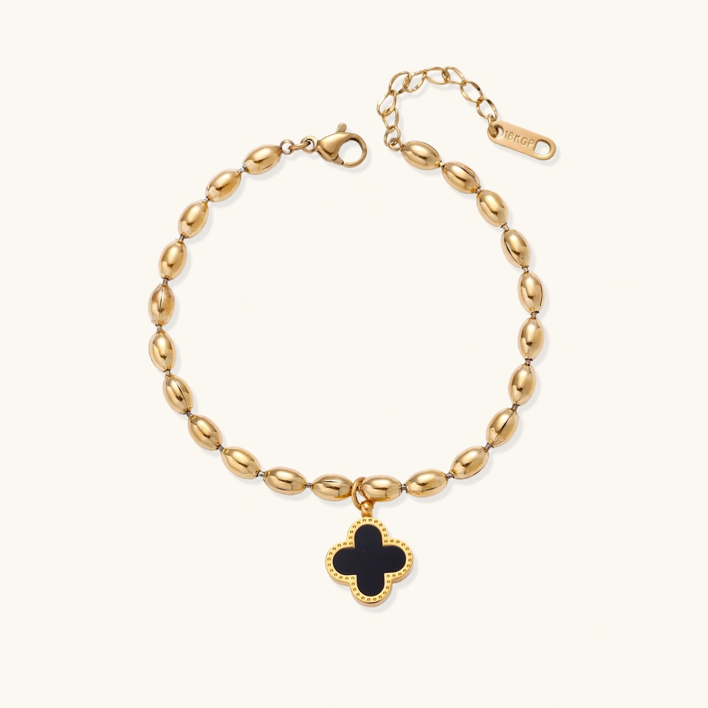 18K gold-plated oval bead bracelet with a four-leaf clover charm in mother-of-pearl or black enamel, adjustable lobster clasp, on white background.