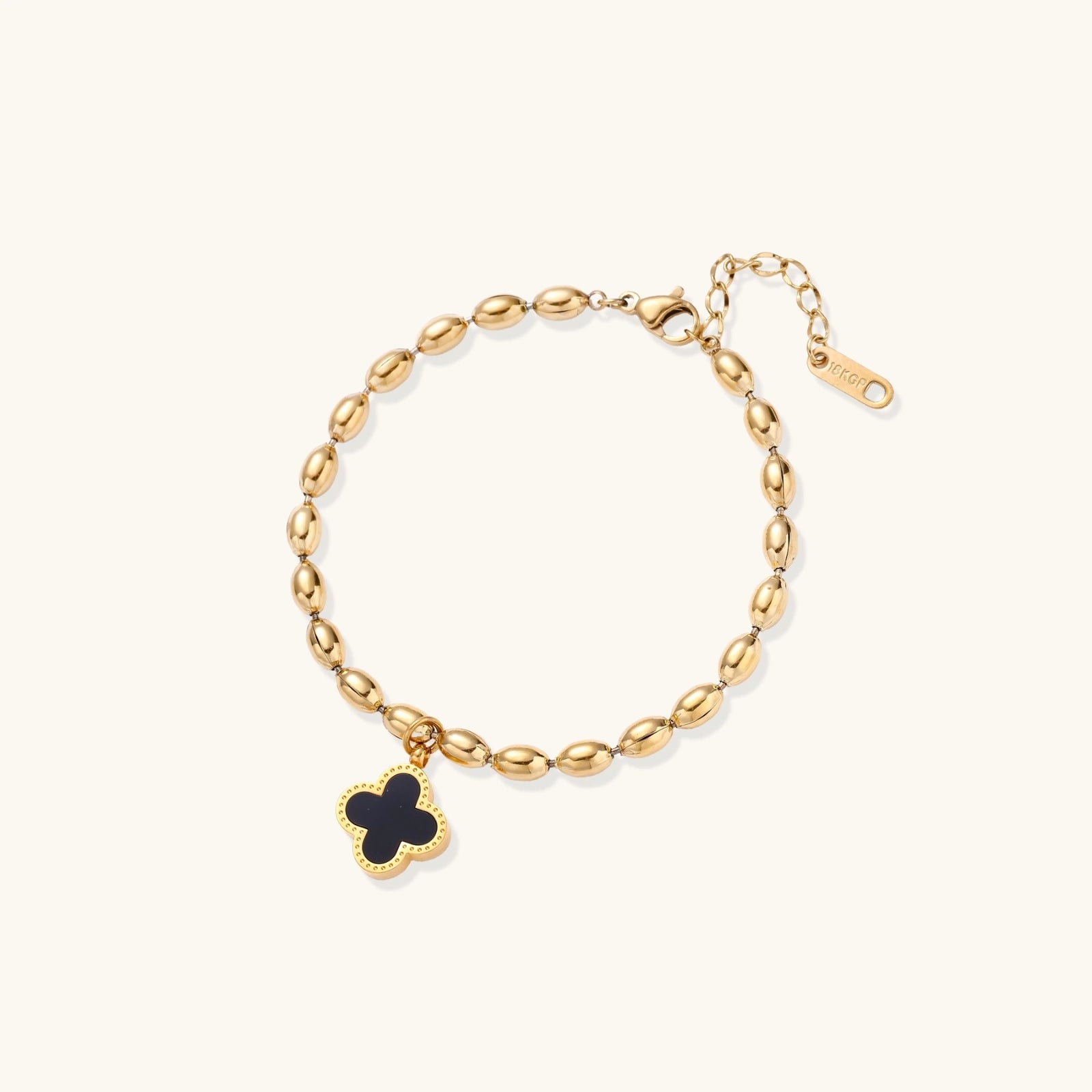 18K gold-plated oval bead bracelet with a four-leaf clover charm in mother-of-pearl or black enamel, adjustable lobster clasp, on white background.