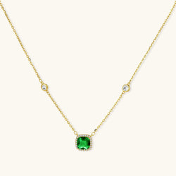 Delicate gold chain necklace featuring square emerald pendant with crystal halo and station accents