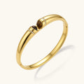 Polished gold bangle with two oval tiger's eye cabochons flanked by pavé diamond accents at center clasp.